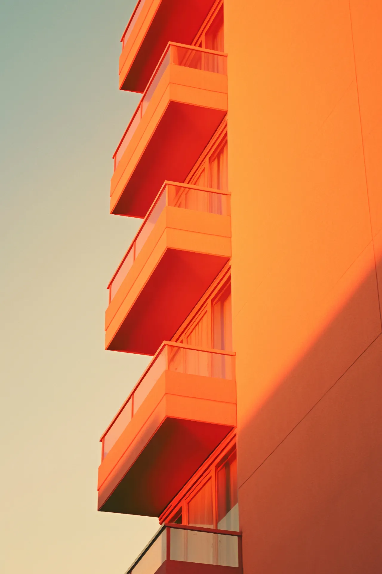 Fachada de edifício em tons quentes e linhas verticais minimalistas.